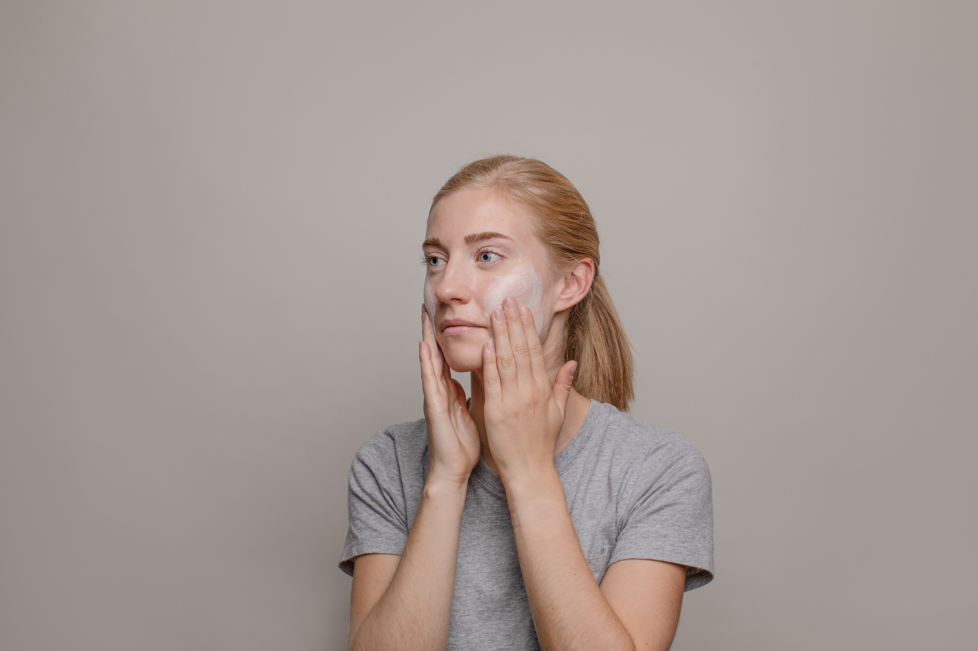 Woman rubbing in skincare cream on her face