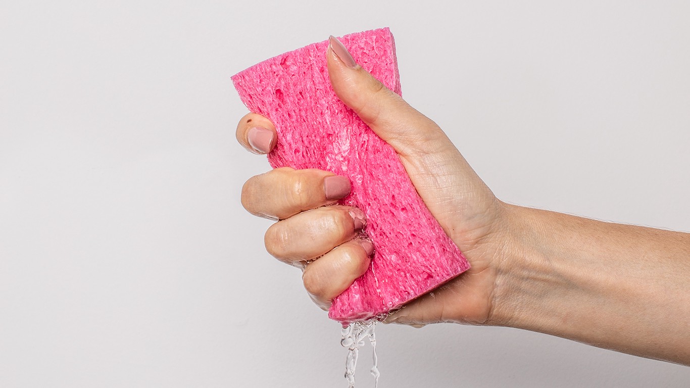 Hand squeezing water out of sponge