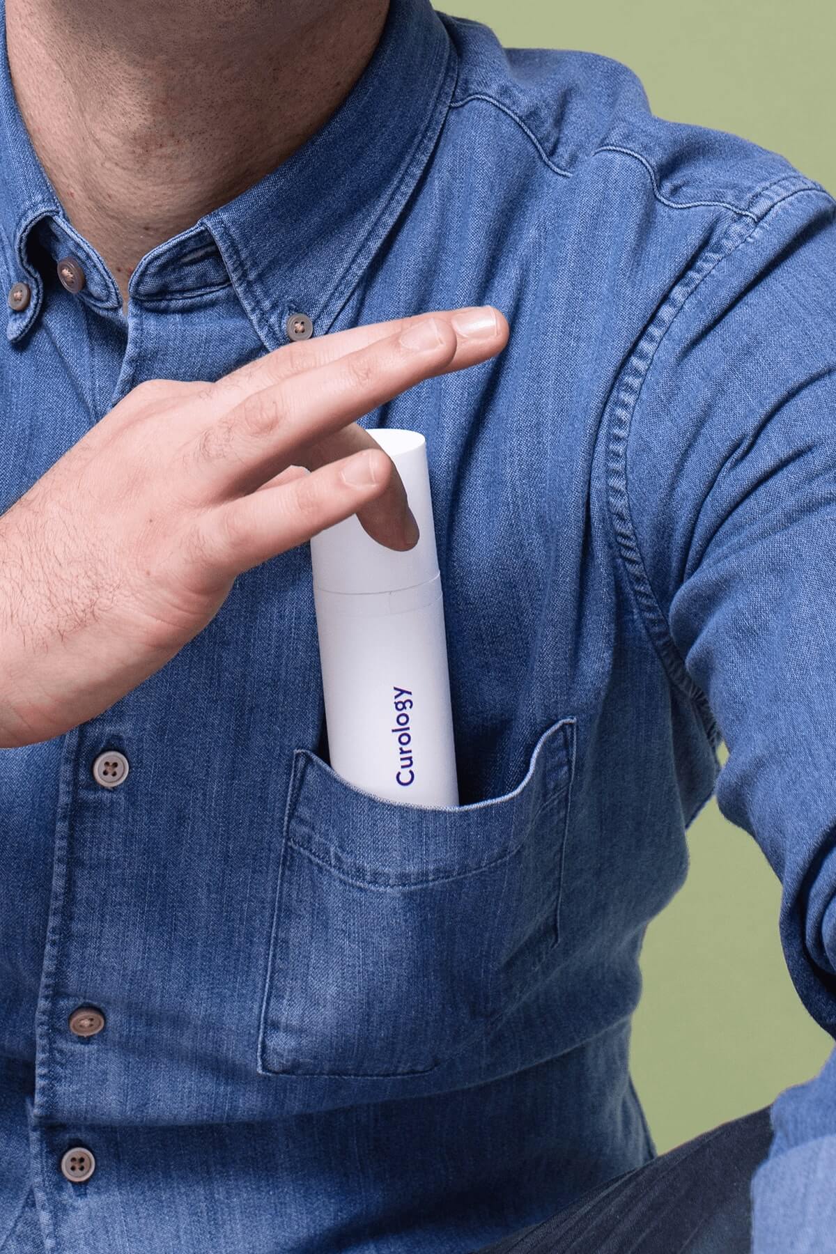 Man wearing blue shirt with curology bottle in pocket