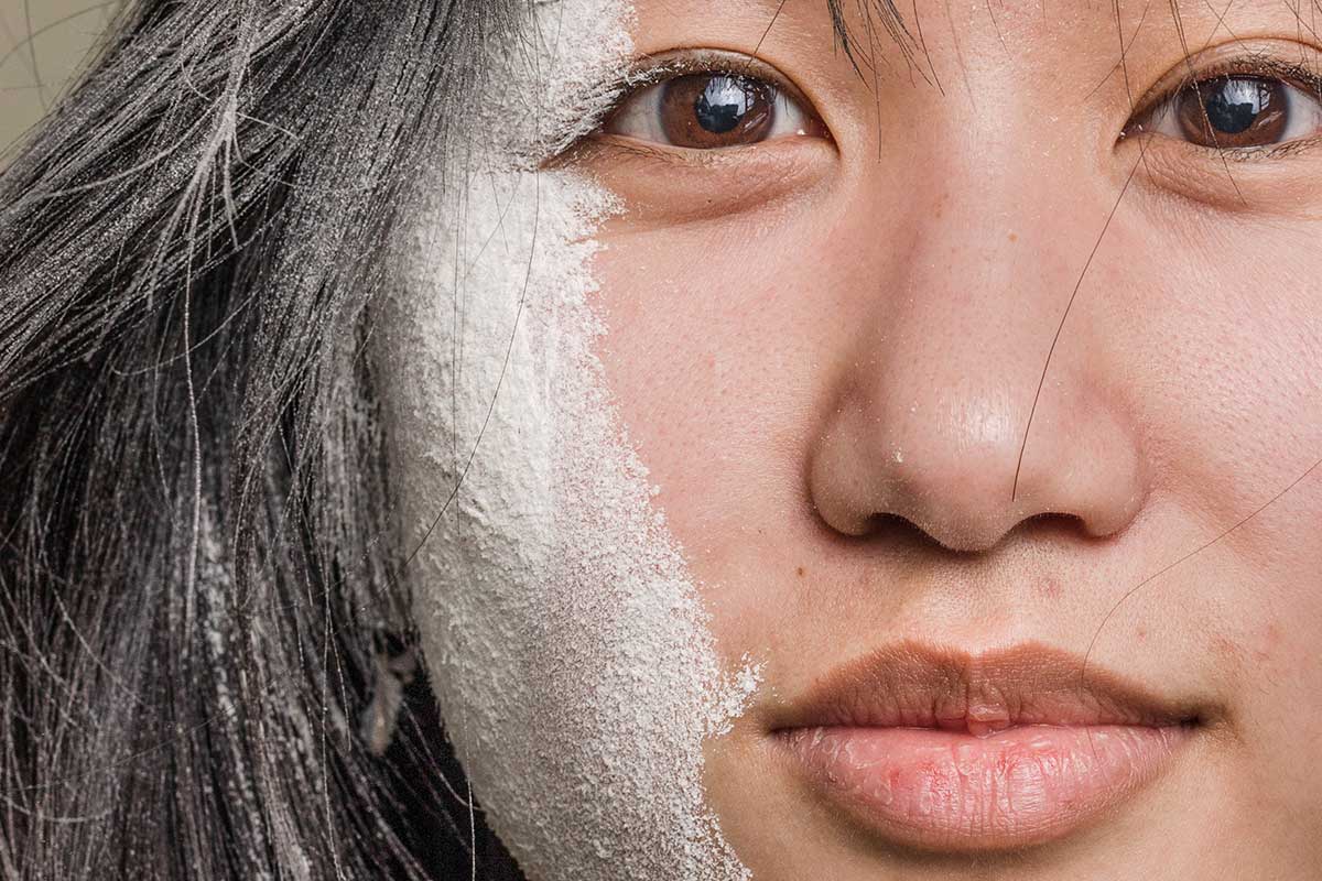 Extreme close-up of a woman's face, partially covered in powder