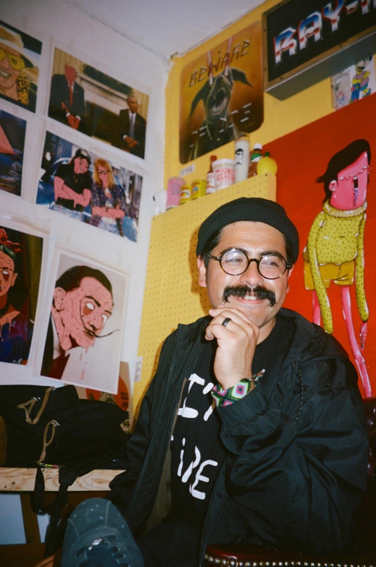 Photo of Richie Velazquez in front of his art
