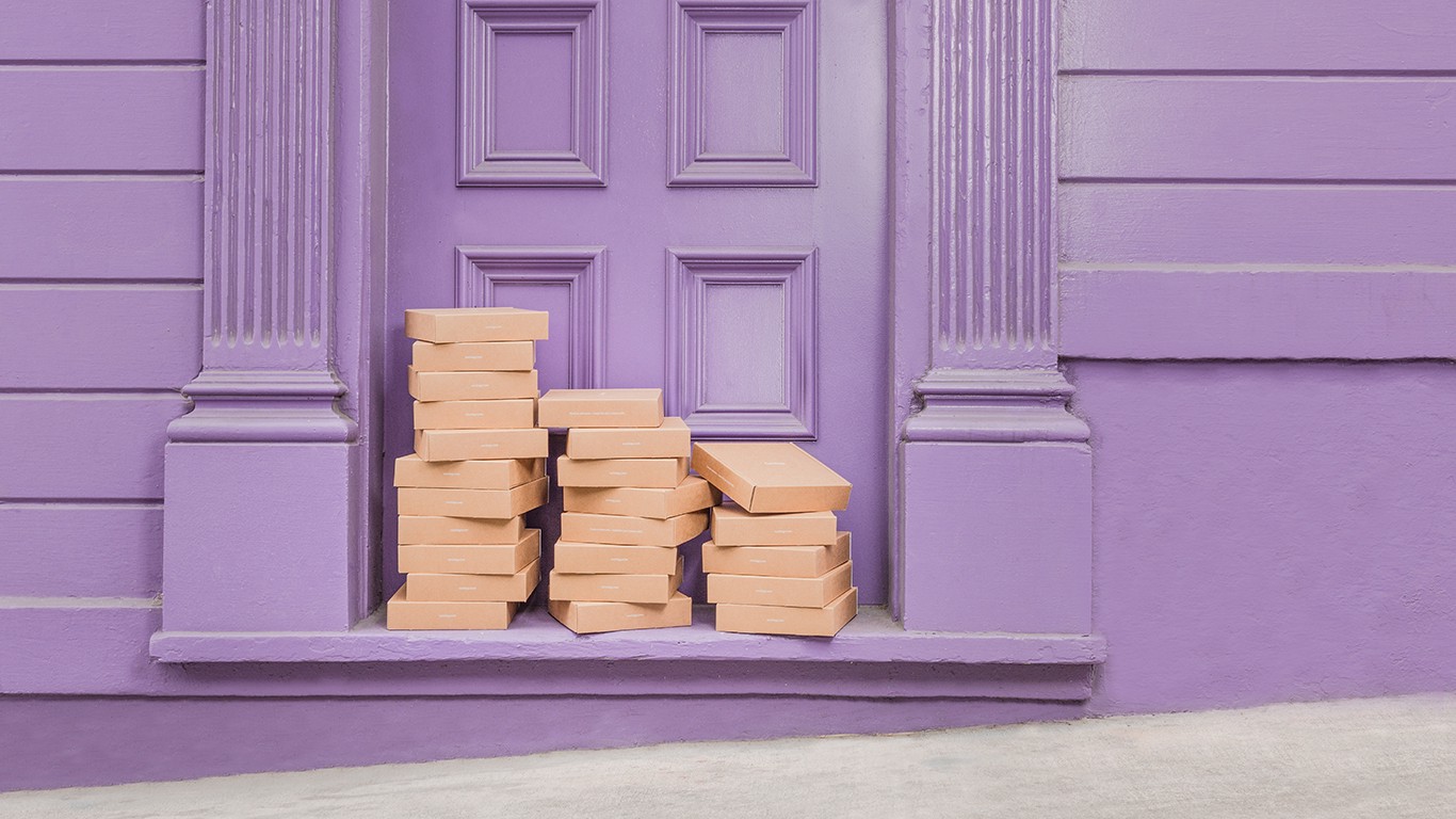 Curology packages piled up in front of purple door