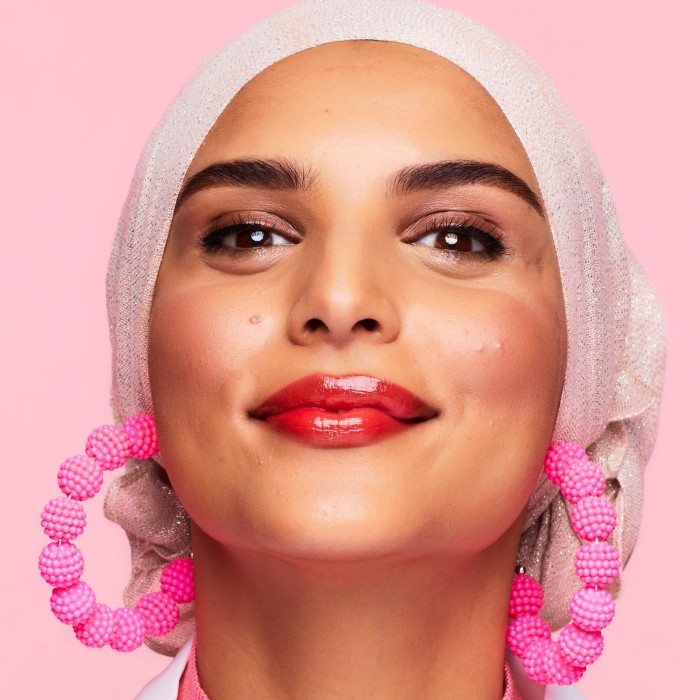Woman smiling with pink background (photo from benefit cosmetics)