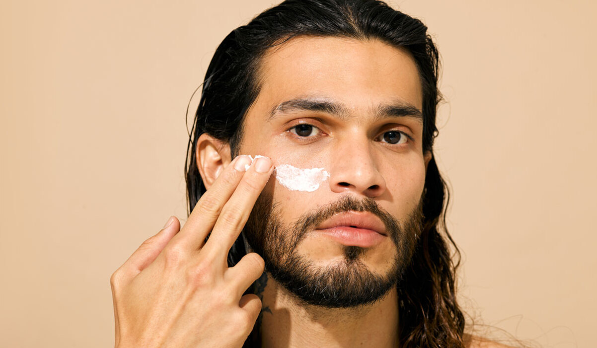 Man applying retinol cream to face
