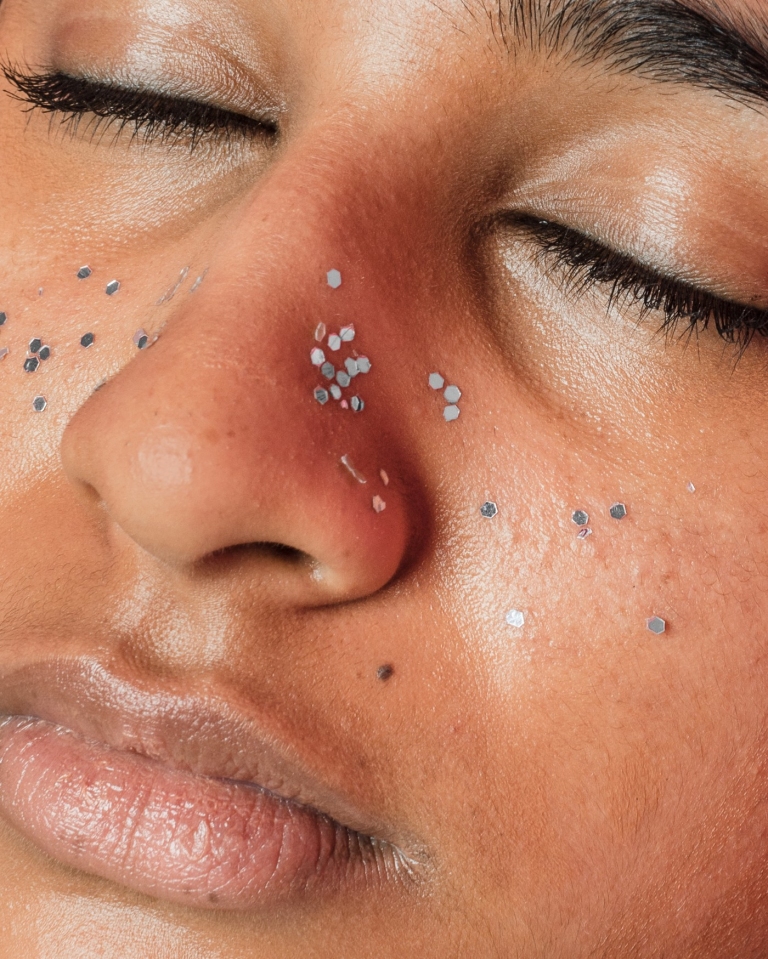 Closeup of woman with beads on her face and closed eyes