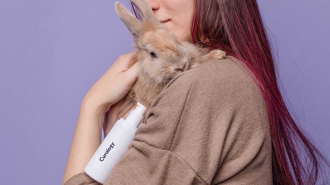 Woman holding rabbit and curology bottle