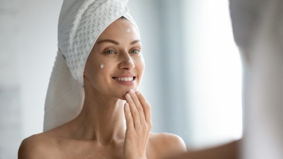 Woman in a Towel Applying Skincare Routine