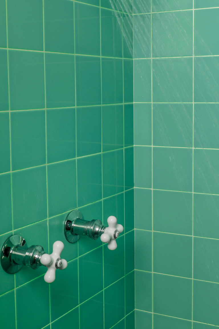 Shower with handles and green tiles