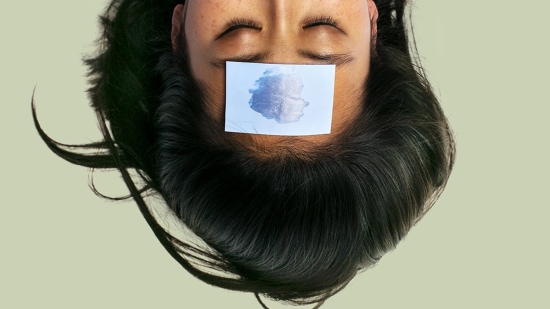 Woman with blue paper on forehead upside down