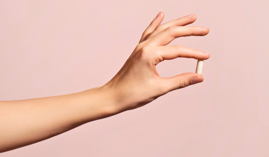 Woman's hand holding pill capsule