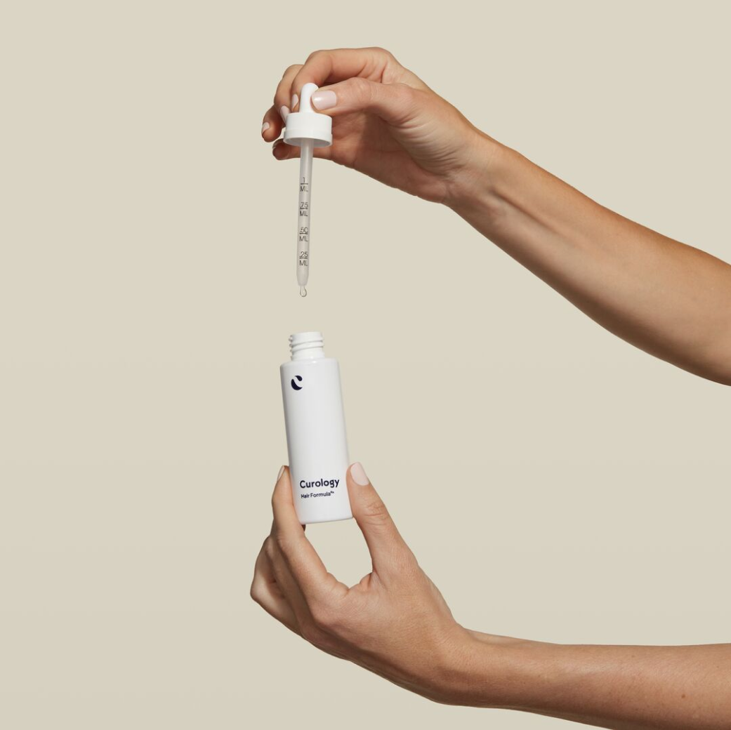 Hands Holding Hair Formula Dropper and Bottle