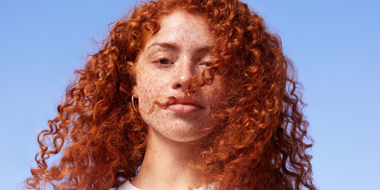 Woman with red curly hair and freckles