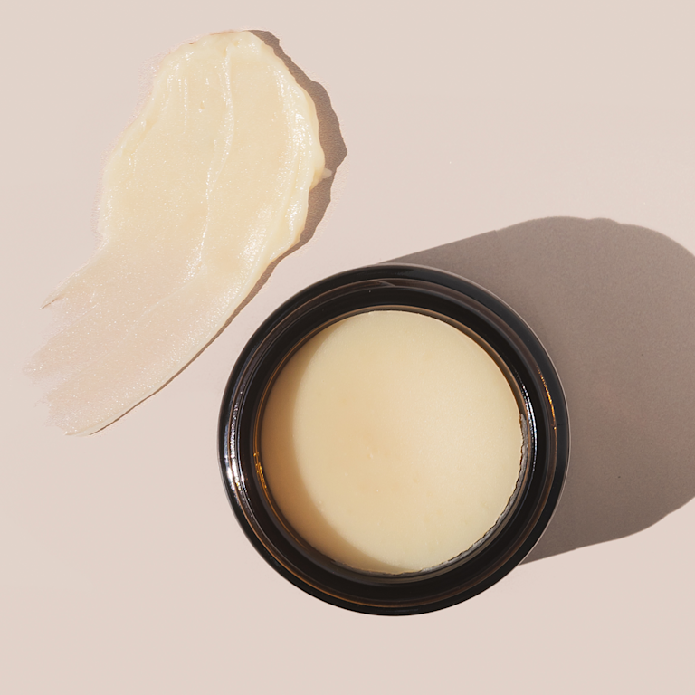 Open jar of beef tallow moisturizer with a swipe; Curology dermatology providers note preservative-free tallow can turn rancid through oxidation and may harbor bacteria.
