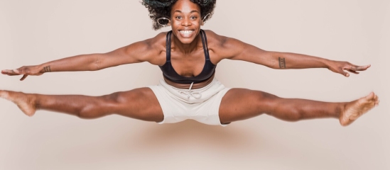 Athlete jumping and smiling doing a split in the air