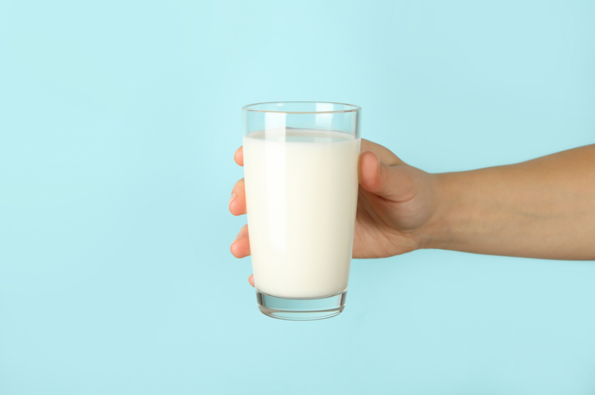 person holding glass of milk