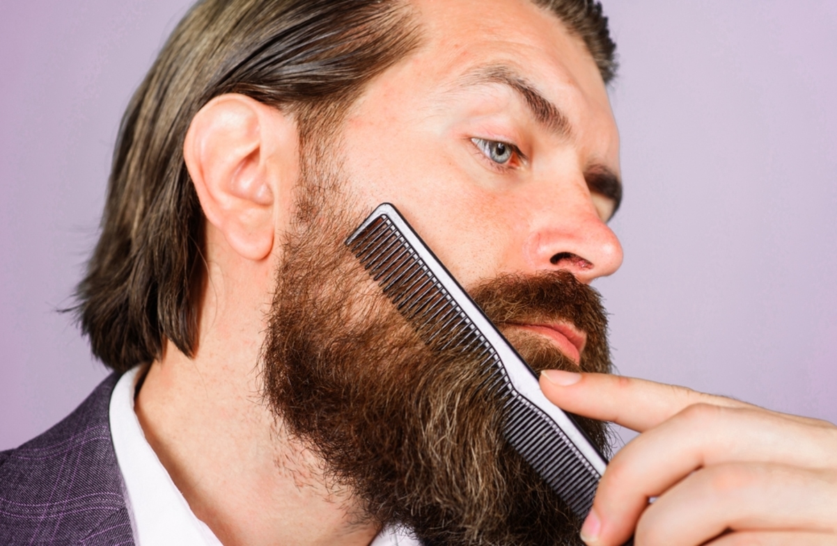 bearded man combs with blade