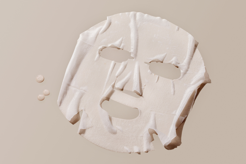 Facial sheet mask on brown background