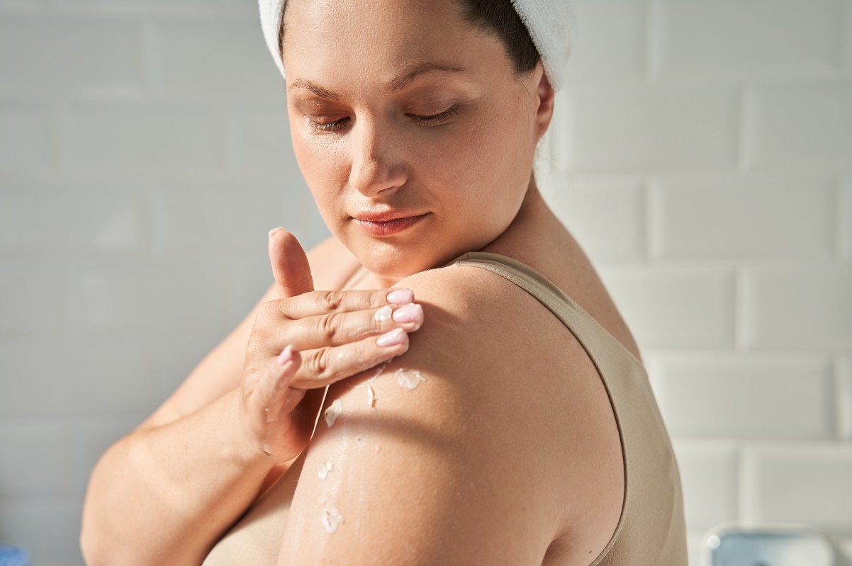 woman applying moisturizer on her skin