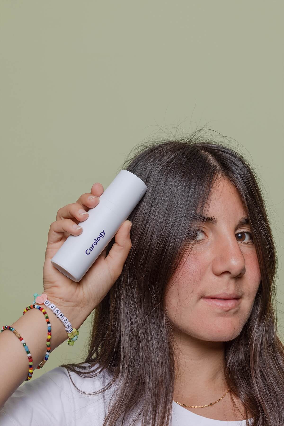 Woman holding bottle with green background