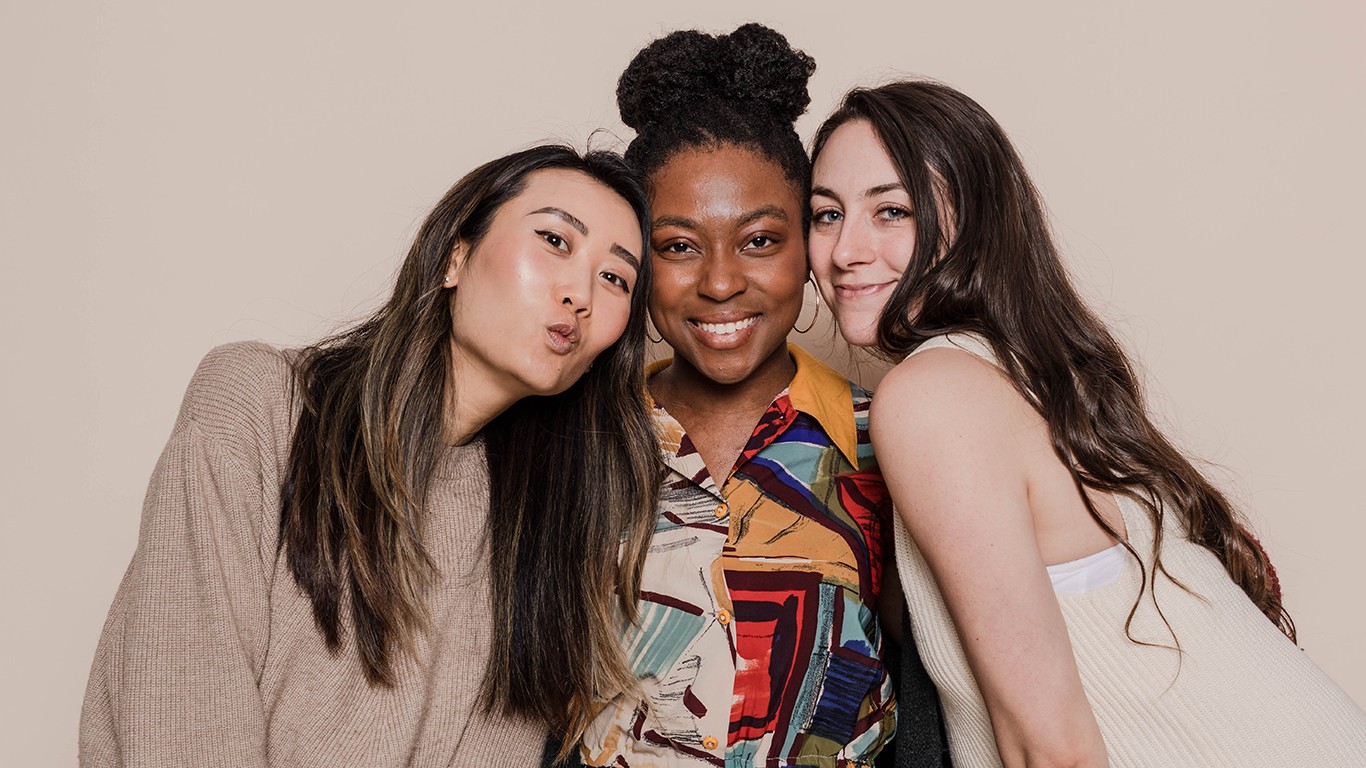 Three women close together with neautral background