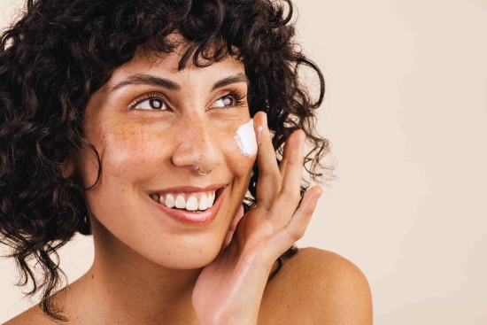 Women applying moisturizer cream on her face