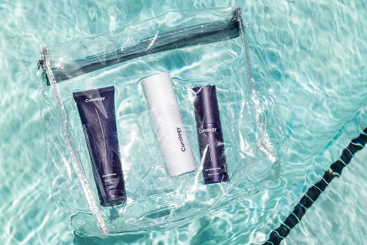 The Curology set in a transparent travel bag, floating in a pool