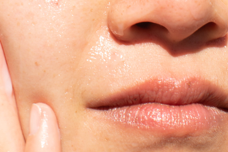 Closeup of dewy nose and mouth with finger on cheek