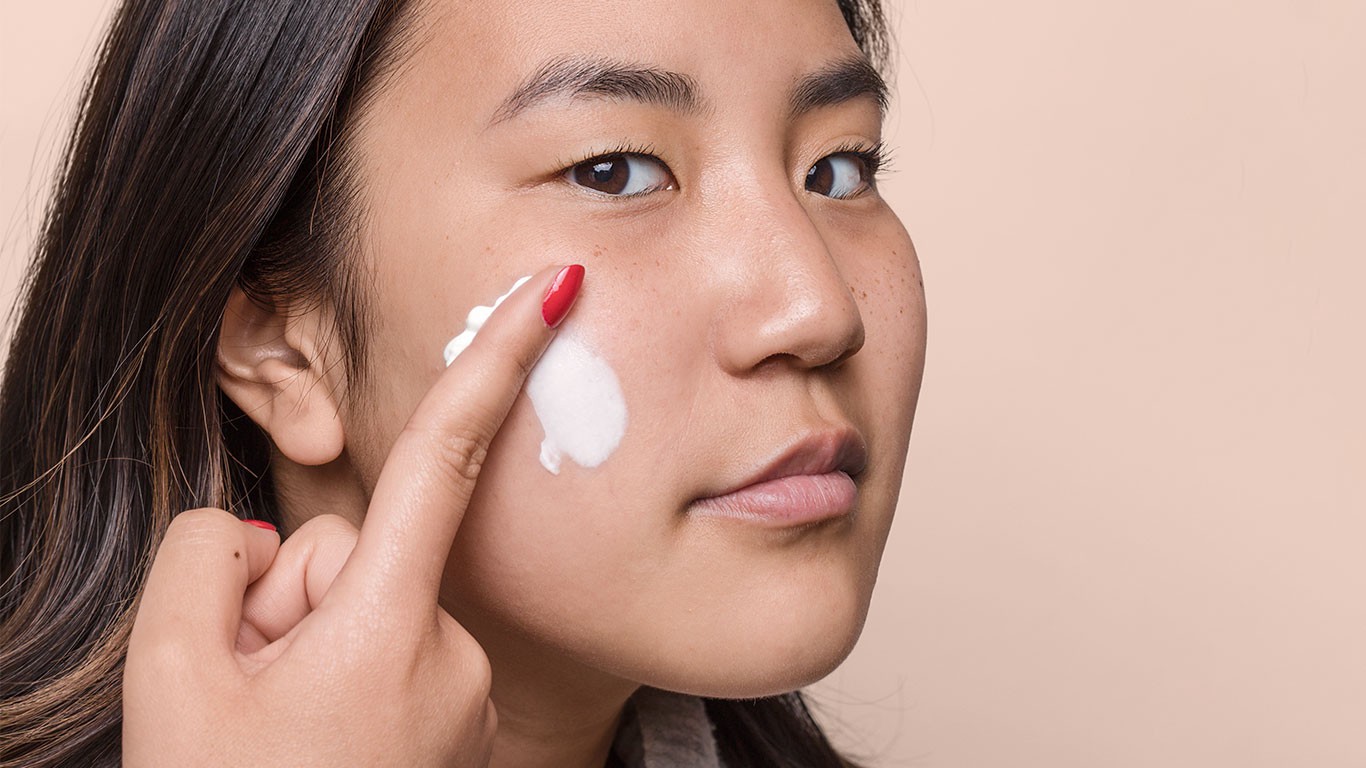 Woman applying skin cream