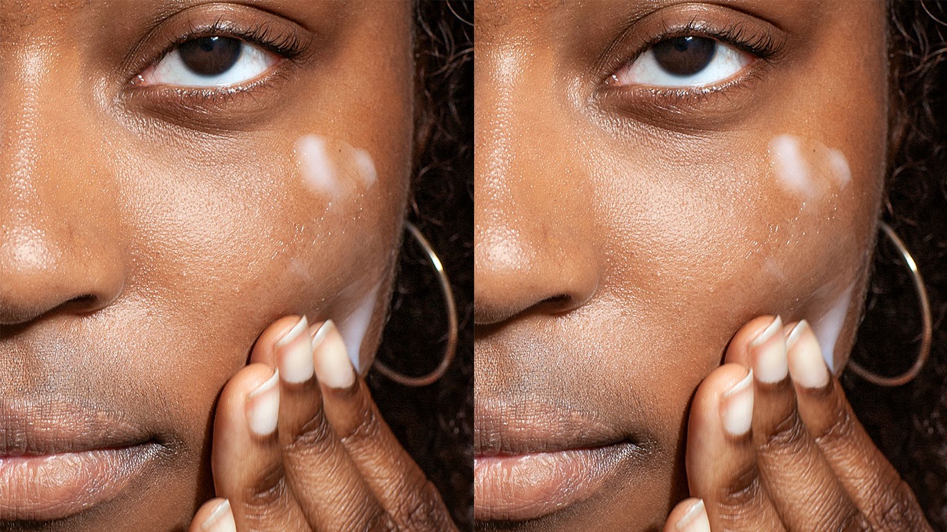 Woman rubbing skincare cream on face