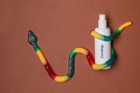 Gummy snake wrapper around curology bottle
