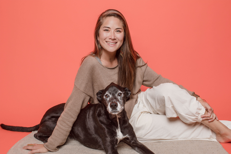Woman and dog sitting with orange background
