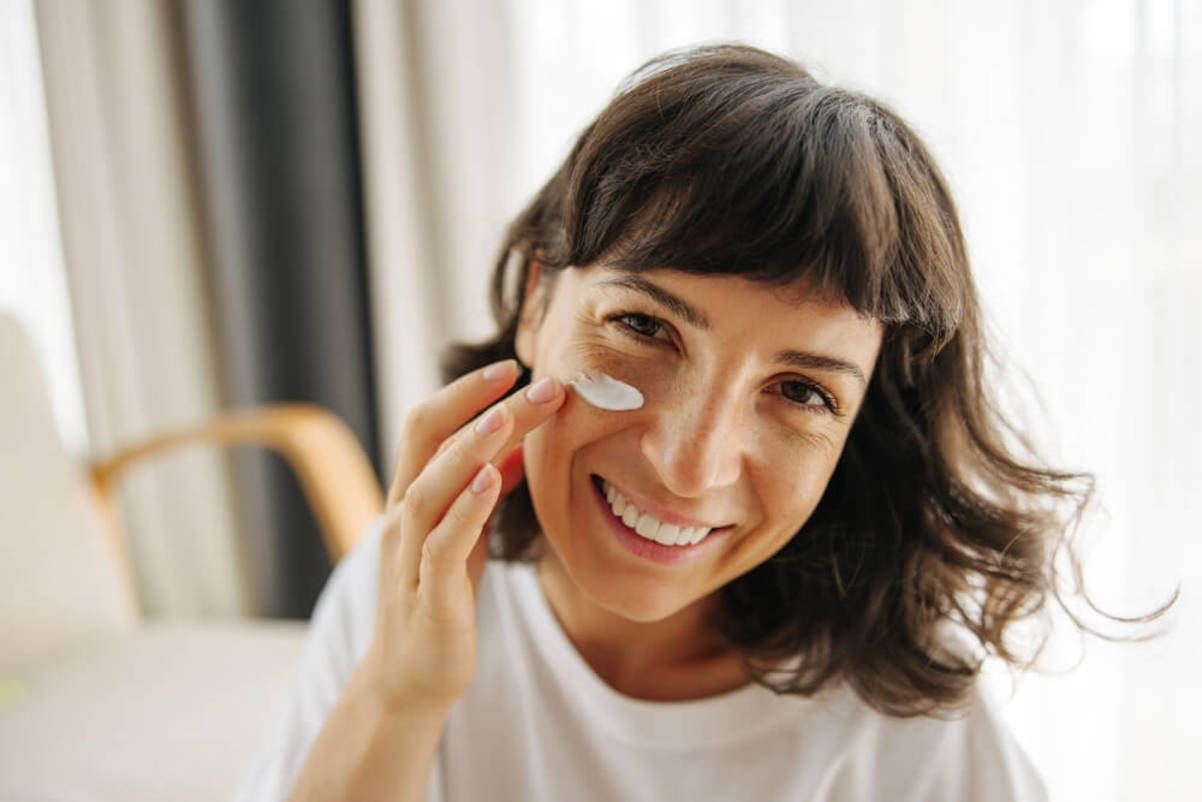 Brunette Woman in White T-shirt Applies Retinol Cream