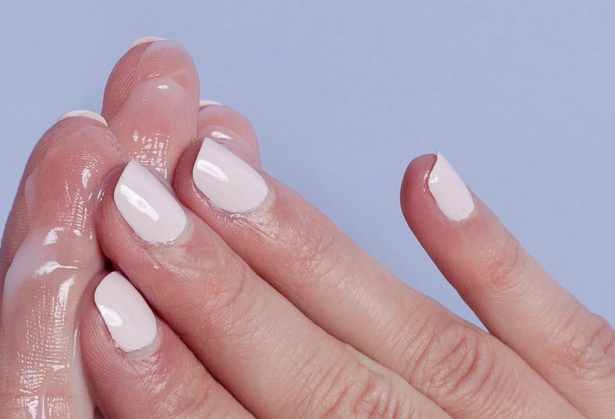 handsHands with white nail polish with hand cream