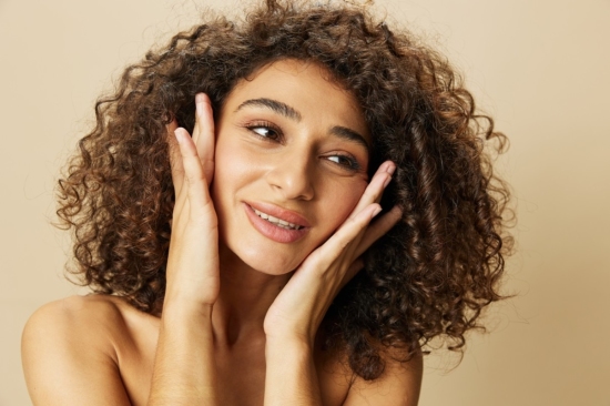 curly hair woman holding her face