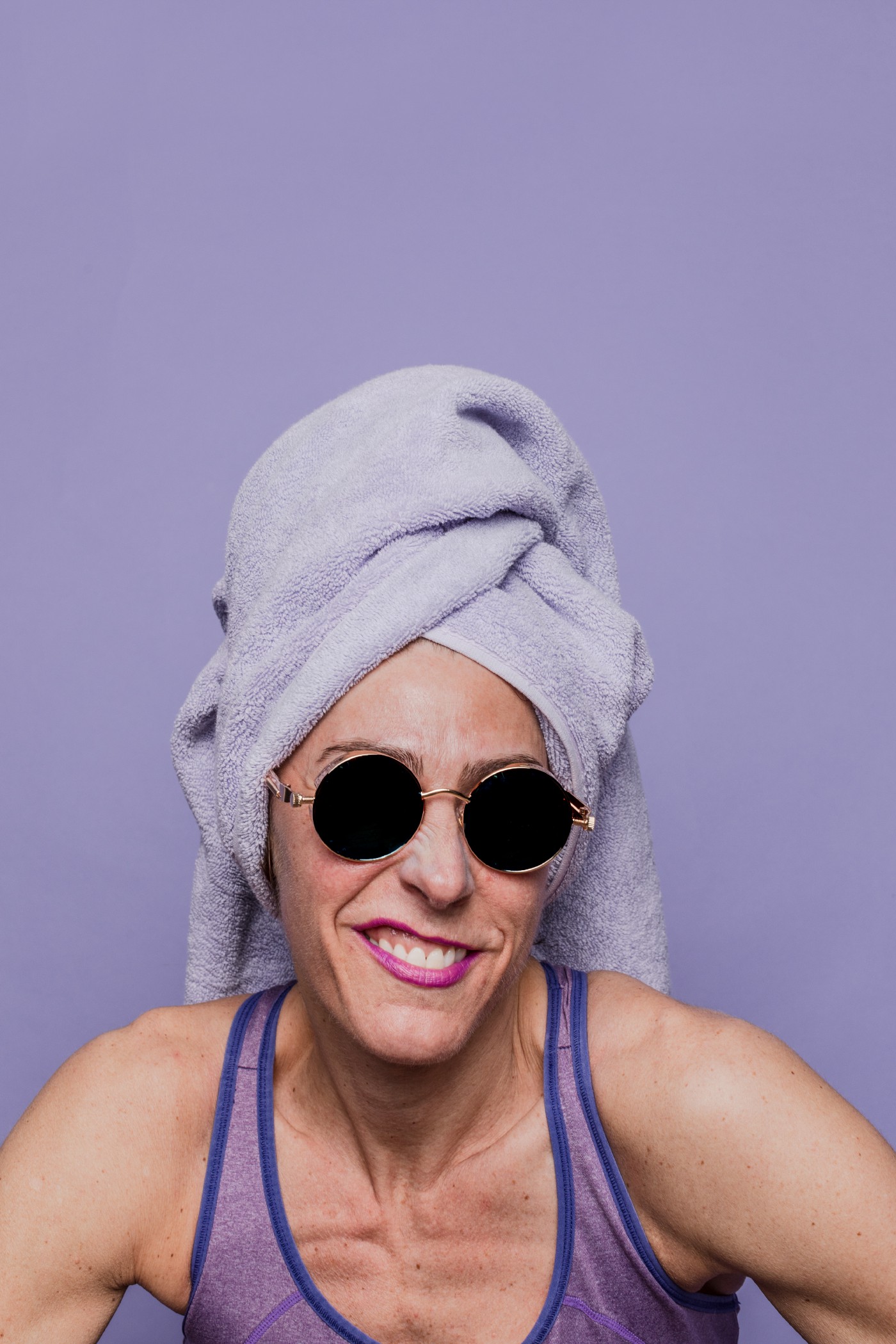 Woman with purple towel on her head wearing sunglasses