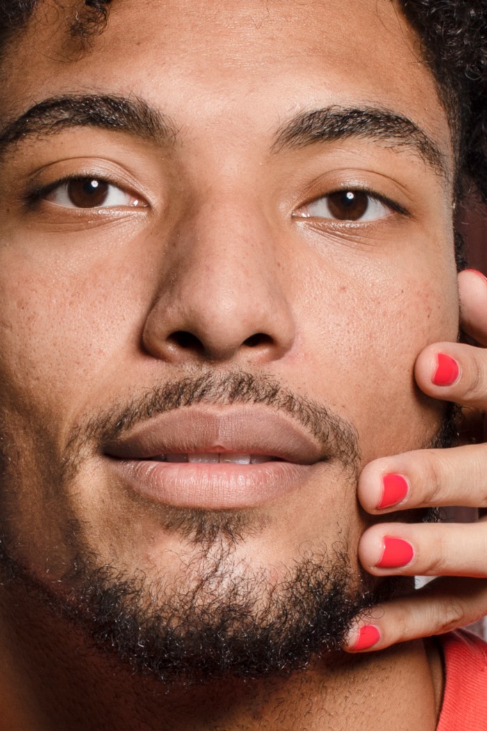 Closeup of man with a hand touching his face (with red fingernails)