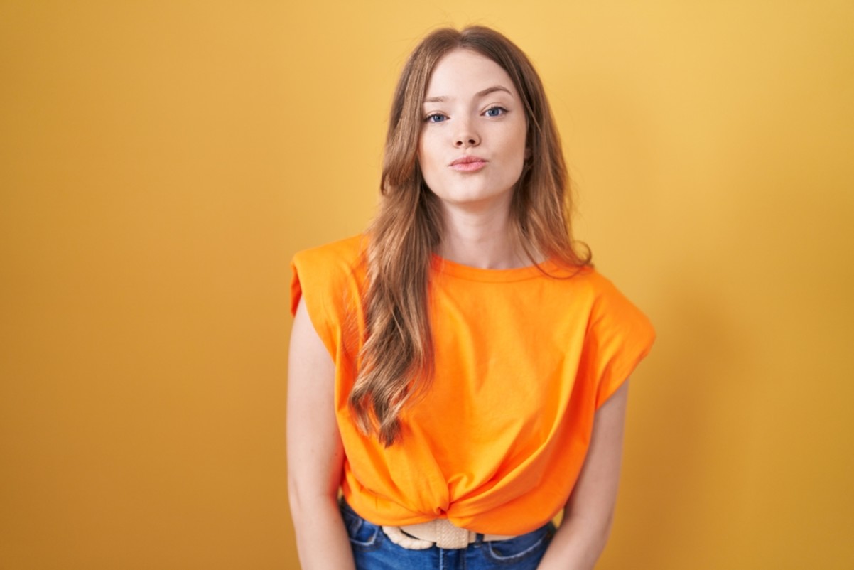 woman standing over yellow background