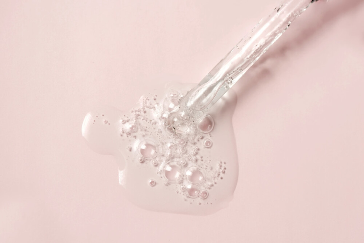 Liquid Oil Serum Drop in Pipette Isolated on Pastel Pink Background