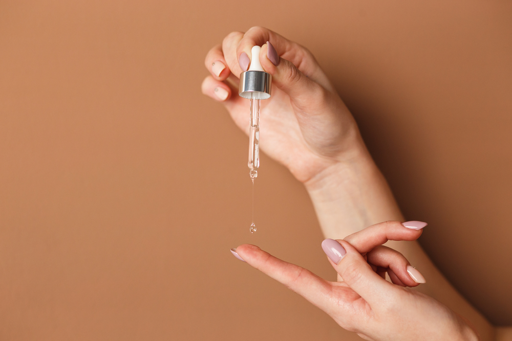 woman hands pouring serum on top