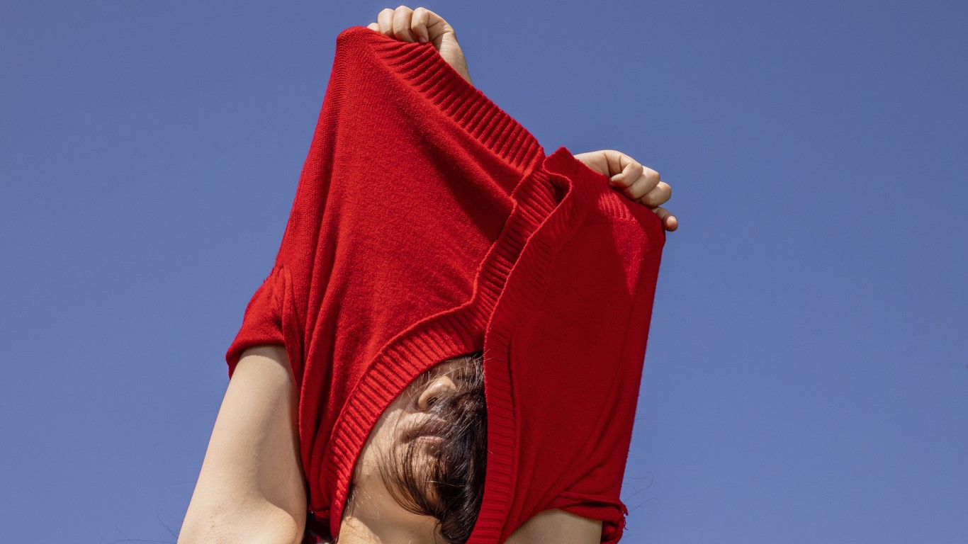 Person removing red top with purple background