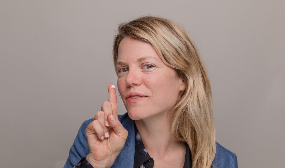 Woman holding skincare cream on her finger