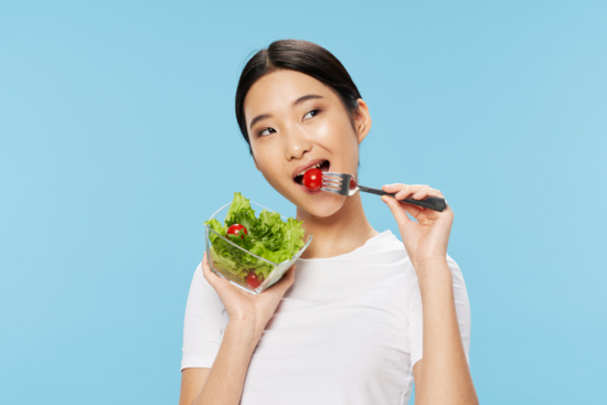 Slim woman eating a salad 