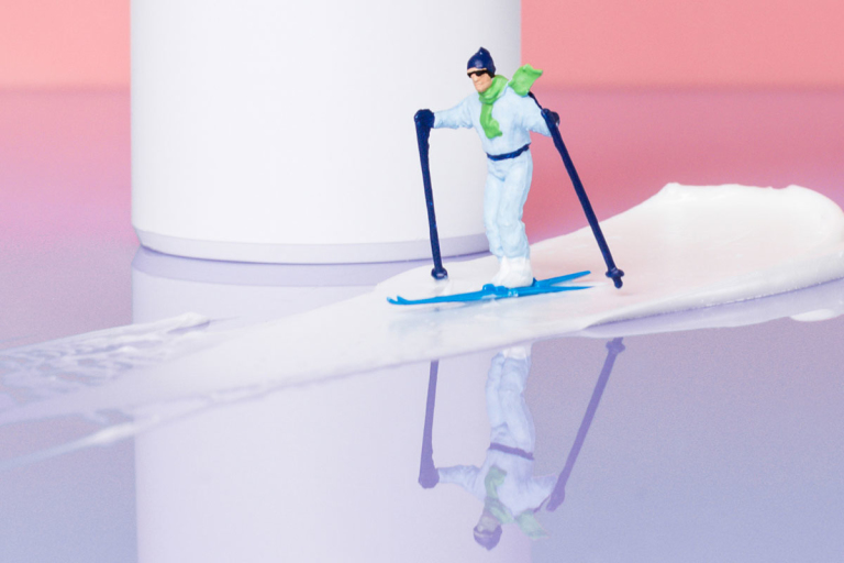 A figurine of a skiier sitting on a smear of Curology cream