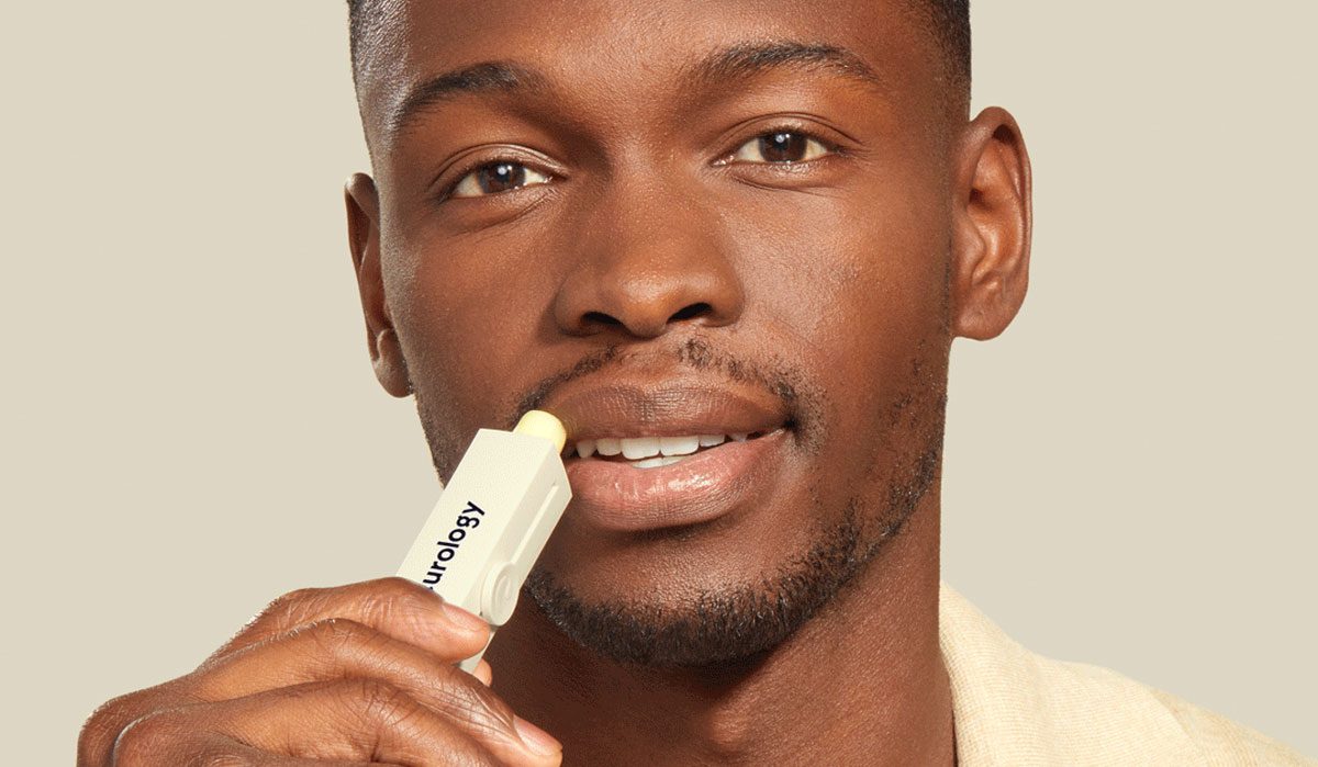 Male applying Curology lip balm for irritation