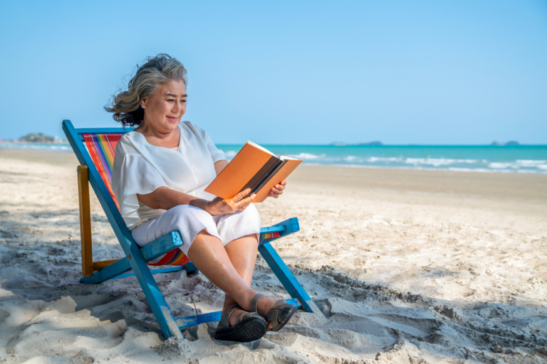 Happy senior woman sitting on beach chair