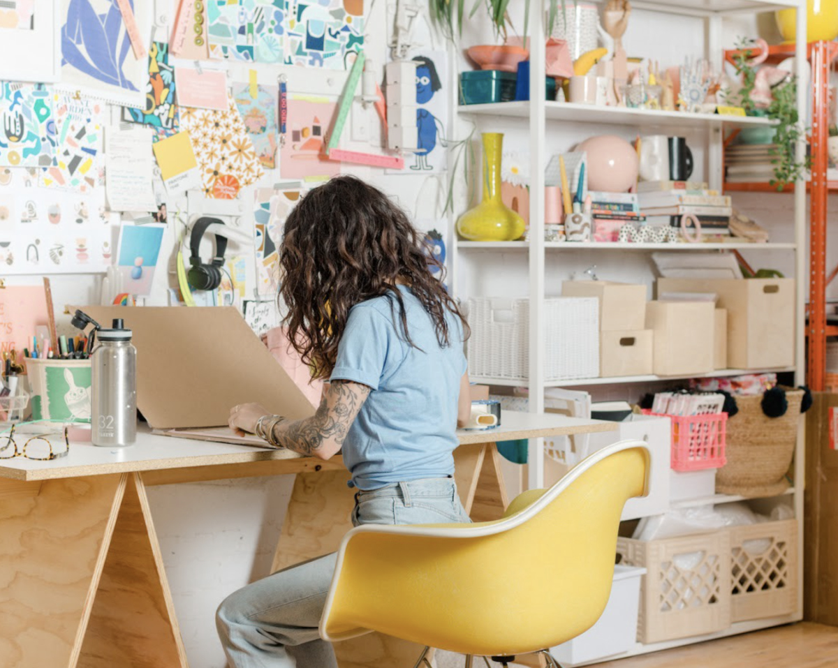 Woman sitting at desk working on art