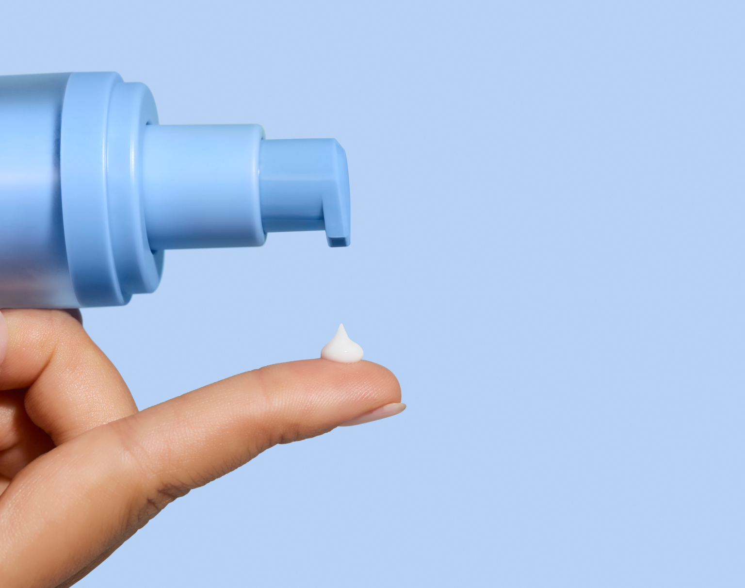 Close-up of Curology Dayprime Rx being dispensed onto a fingertip, showing the texture of a prescription daytime acne treatment and primer.