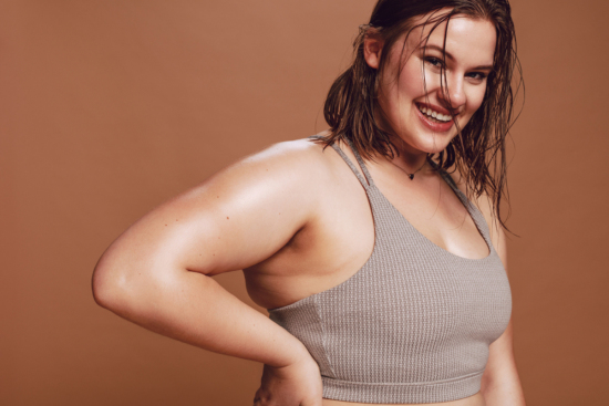 Plus size woman smiling and sweating in workout clothes