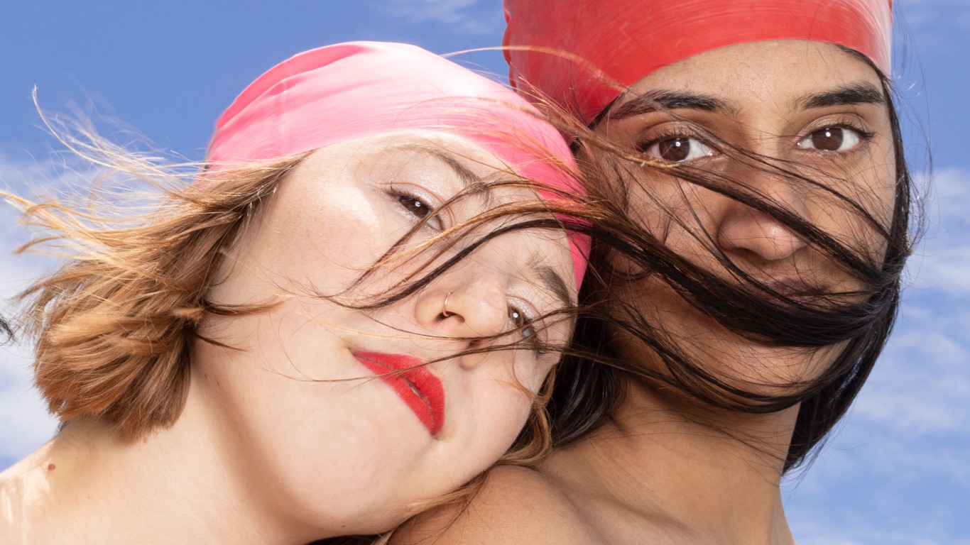 Women with swim caps. Leaning head on shoulder