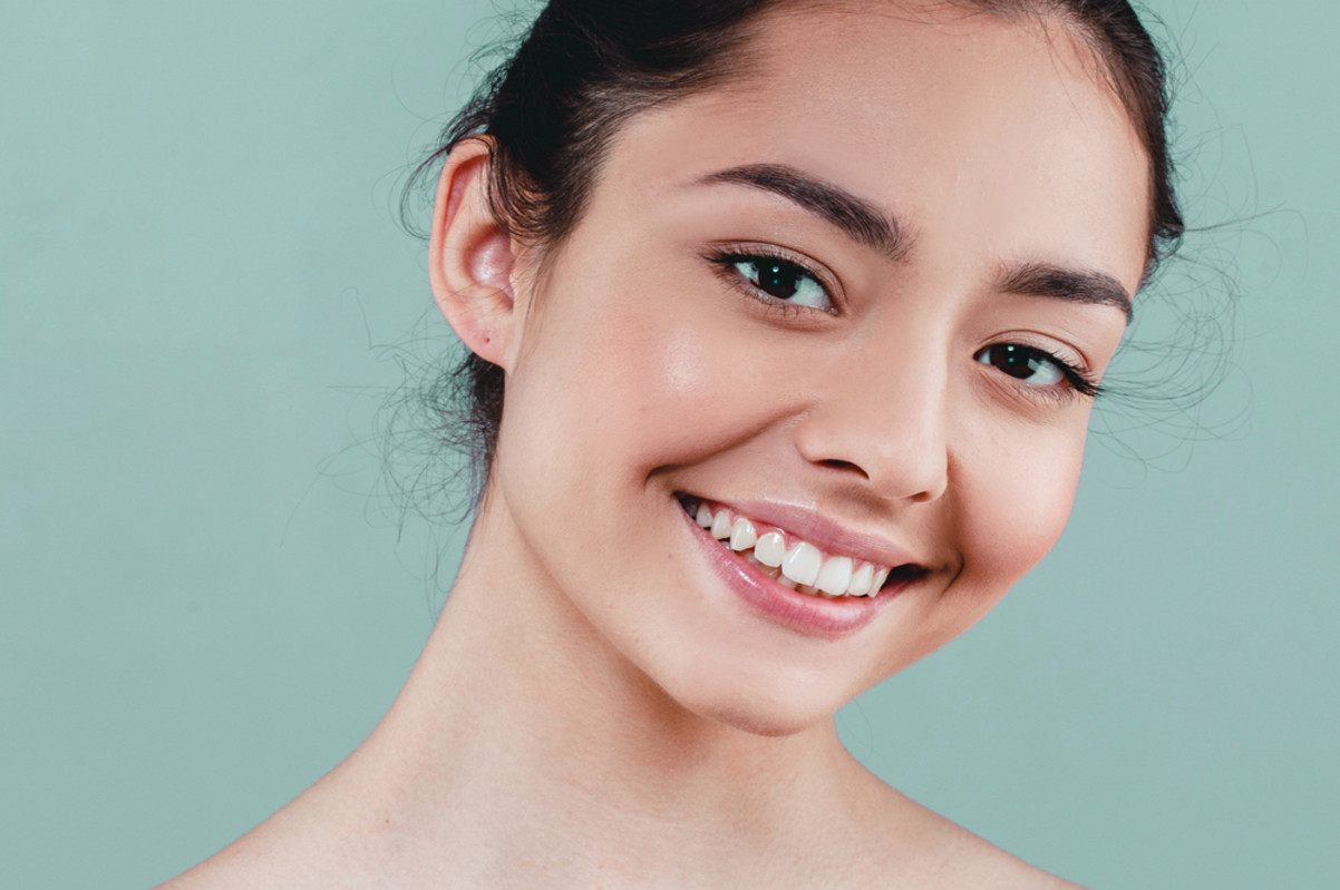 woman smiling in front of green background